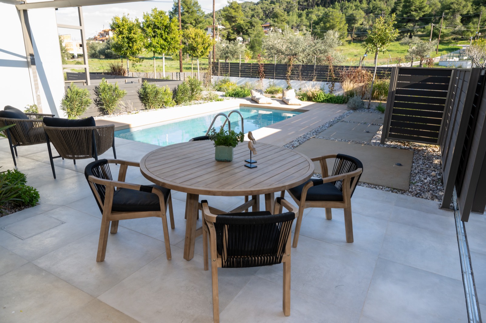 Outdoor dining terrace overlooking the pool and olive groves